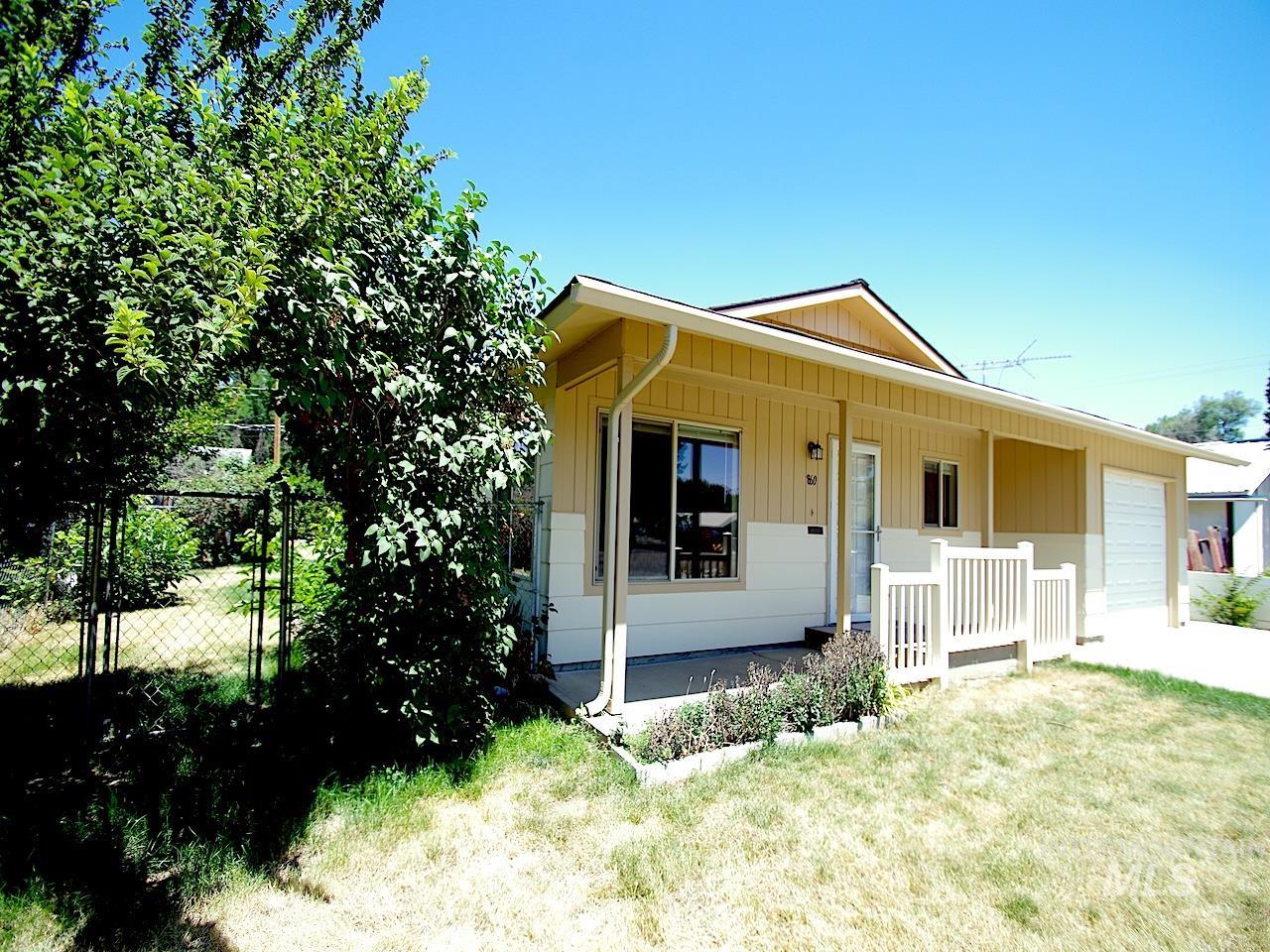 Single-story residence featuring a two-tone exterior, an attached garage, and a covered entry porch with white railing