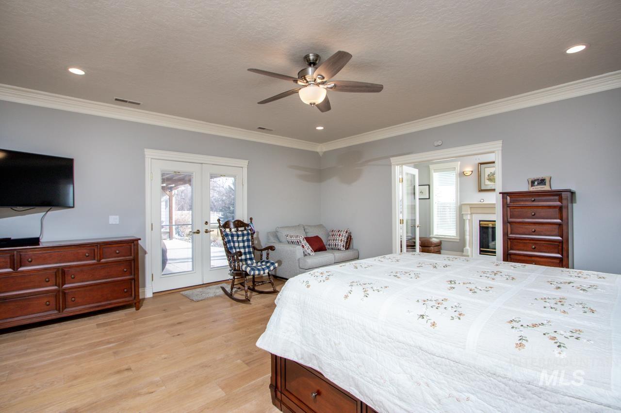 Bedroom featuring french doors, access to outside, a ceiling fan, ornamental molding, and multiple windows