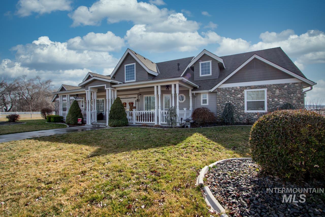 View of front of home featuring a porch, a front lawn, and stone siding