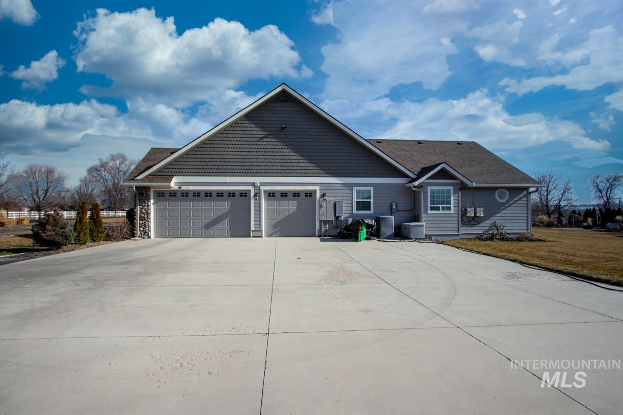 View of front facade featuring concrete driveway, a garage, and a front lawn