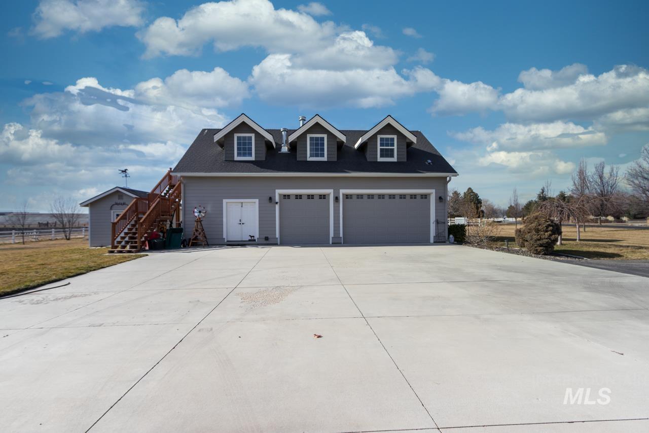 View of front of house featuring driveway, a garage, and a front yard