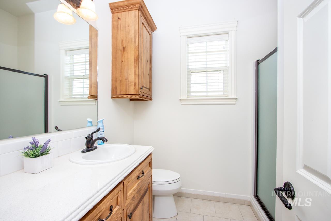 Bathroom with a shower stall, vanity, and light tile patterned floors