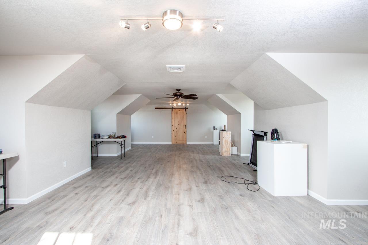 Bonus room featuring light wood-type flooring and ceiling fan
