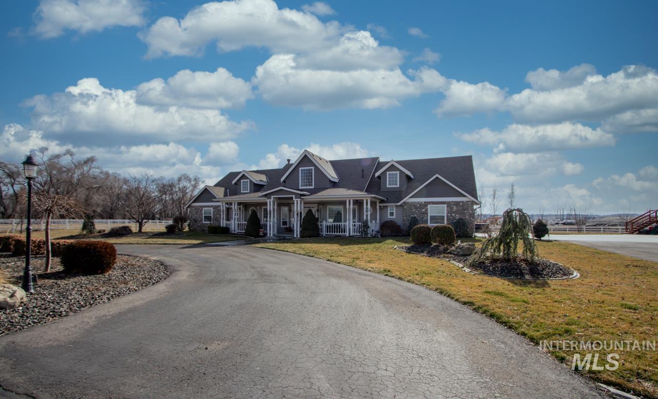Cape cod-style house featuring covered porch and curved driveway