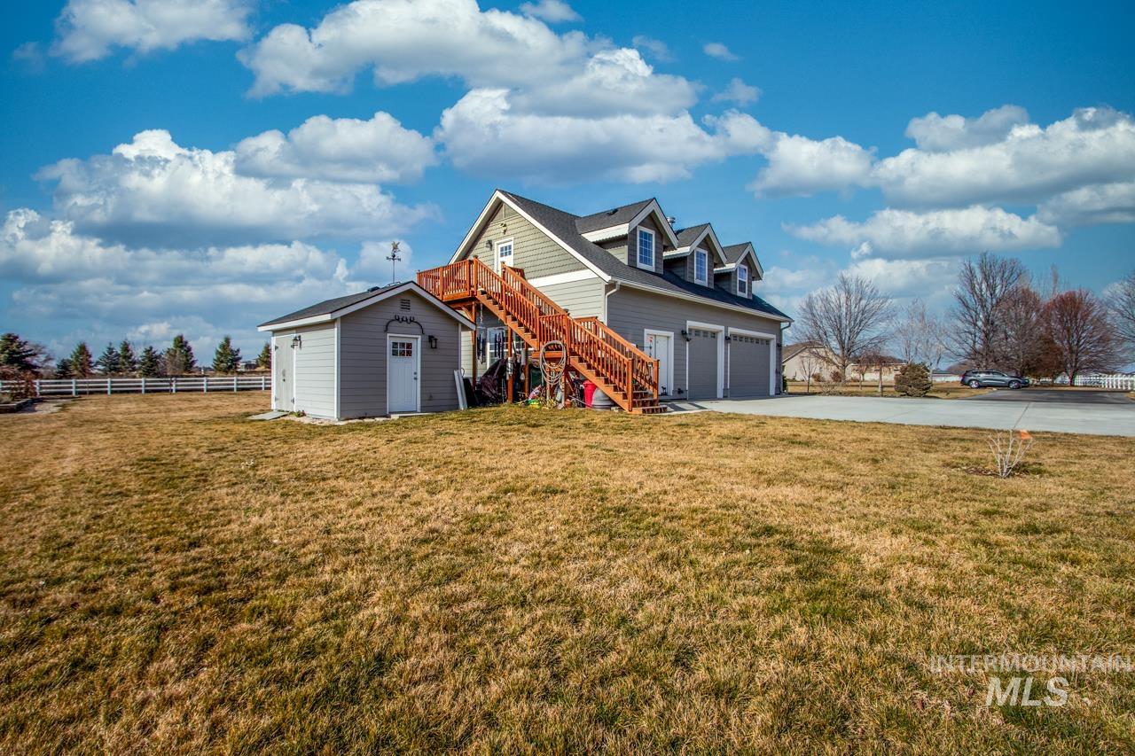 Rear view of house featuring concrete driveway, an outbuilding, and a garage