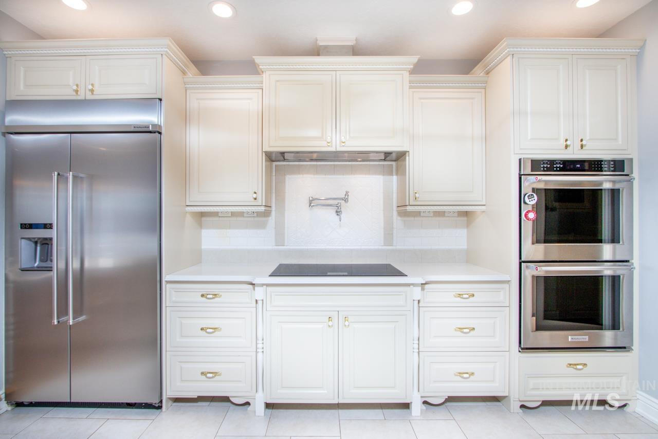 Kitchen with stainless steel appliances, recessed lighting, decorative backsplash, light stone counters, and light tile patterned floors
