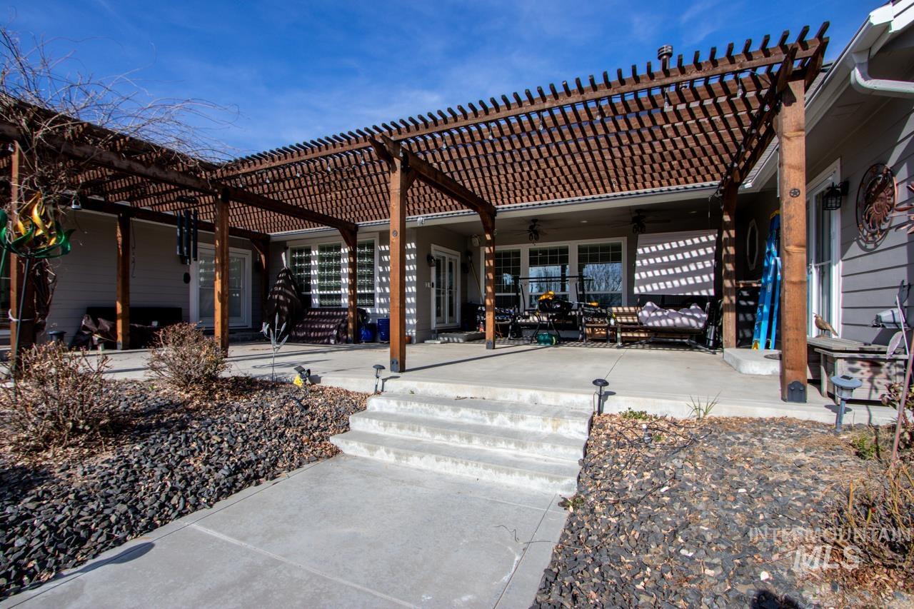 Rear view of property with a pergola, a patio area, a tile roof, and a ceiling fan