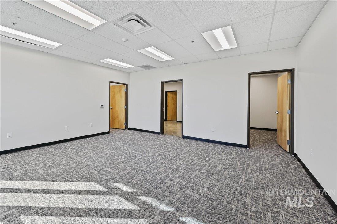 Spare room featuring a paneled ceiling and baseboards