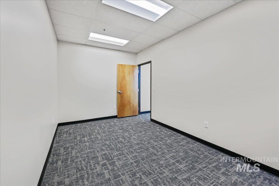 Empty room with a drop ceiling and baseboards