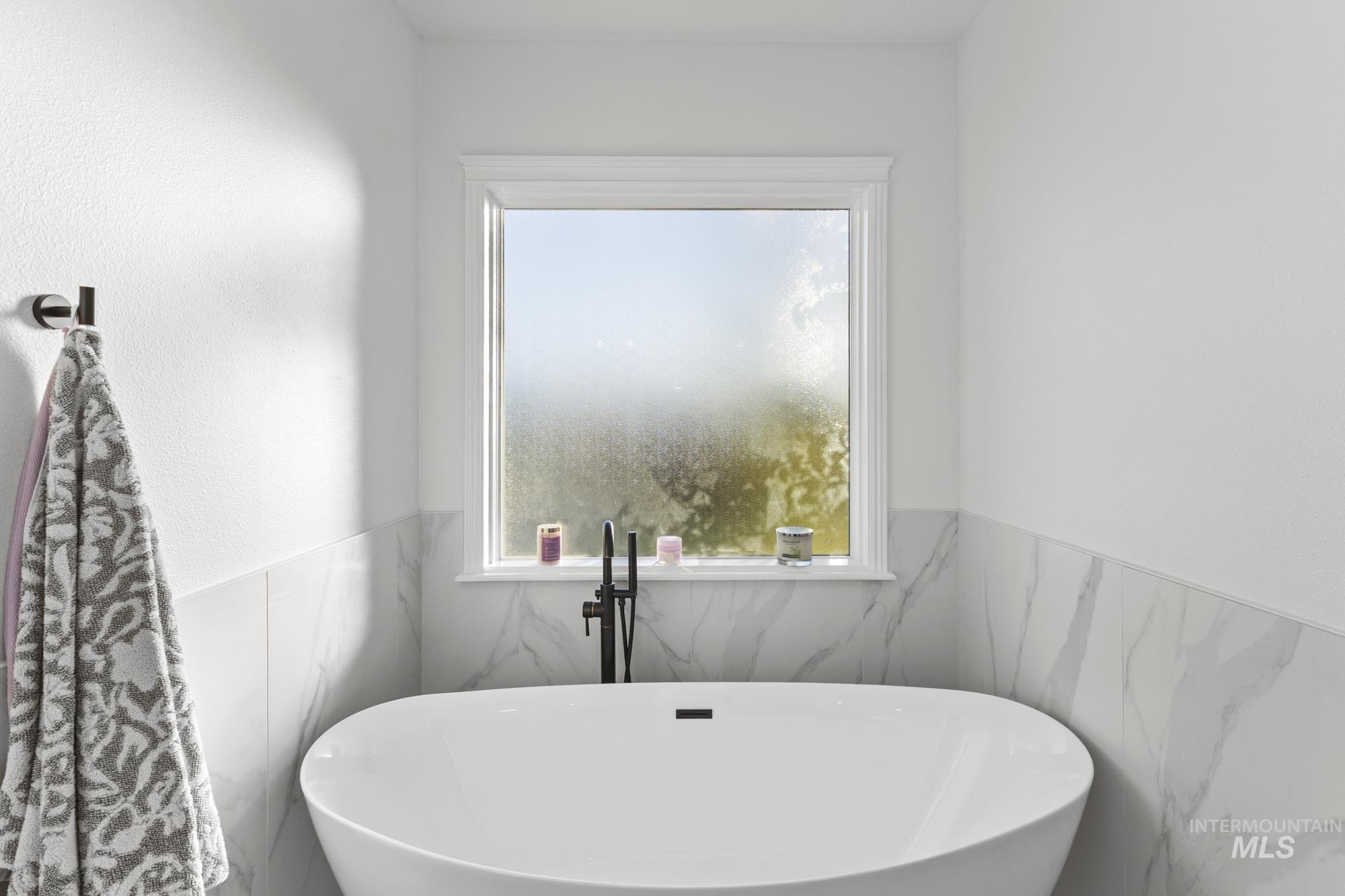 Bathroom with healthy amount of natural light and a freestanding bath