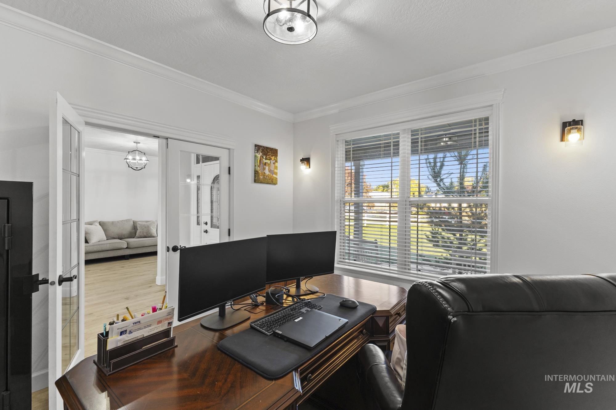 Office area with french doors, crown molding, wood finished floors, and a chandelier