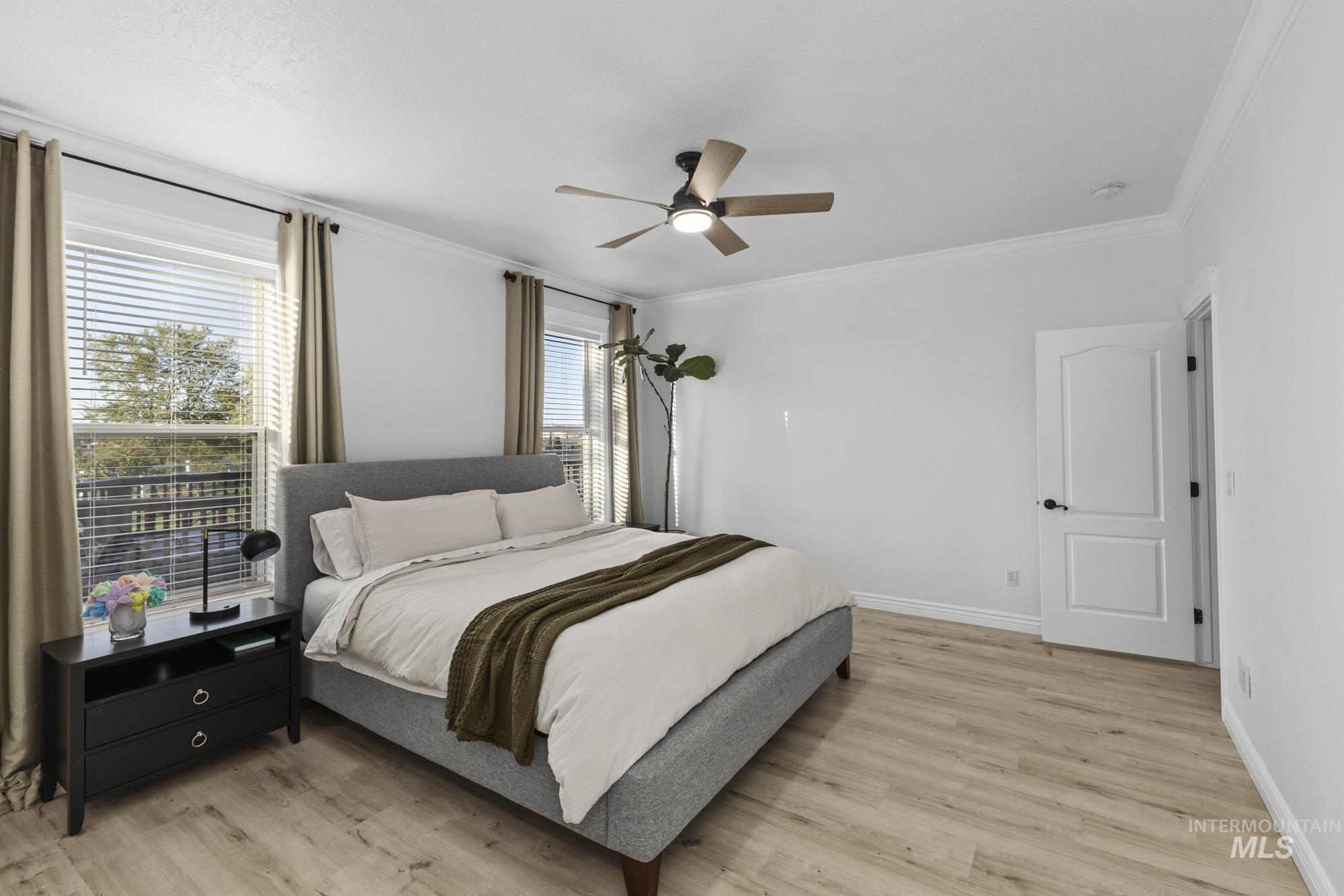Bedroom with crown molding, ceiling fan, and light wood finished floors