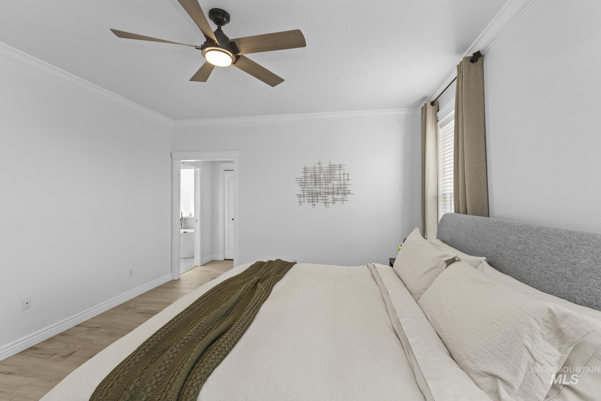 Bedroom featuring crown molding, wood finished floors, and ceiling fan