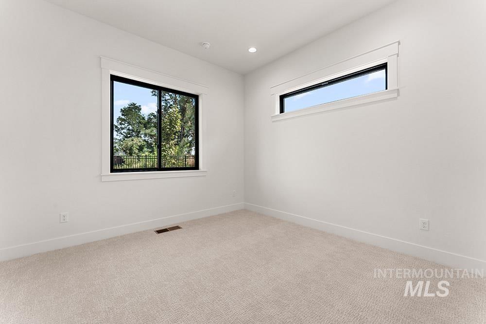 Empty room featuring light colored carpet and recessed lighting