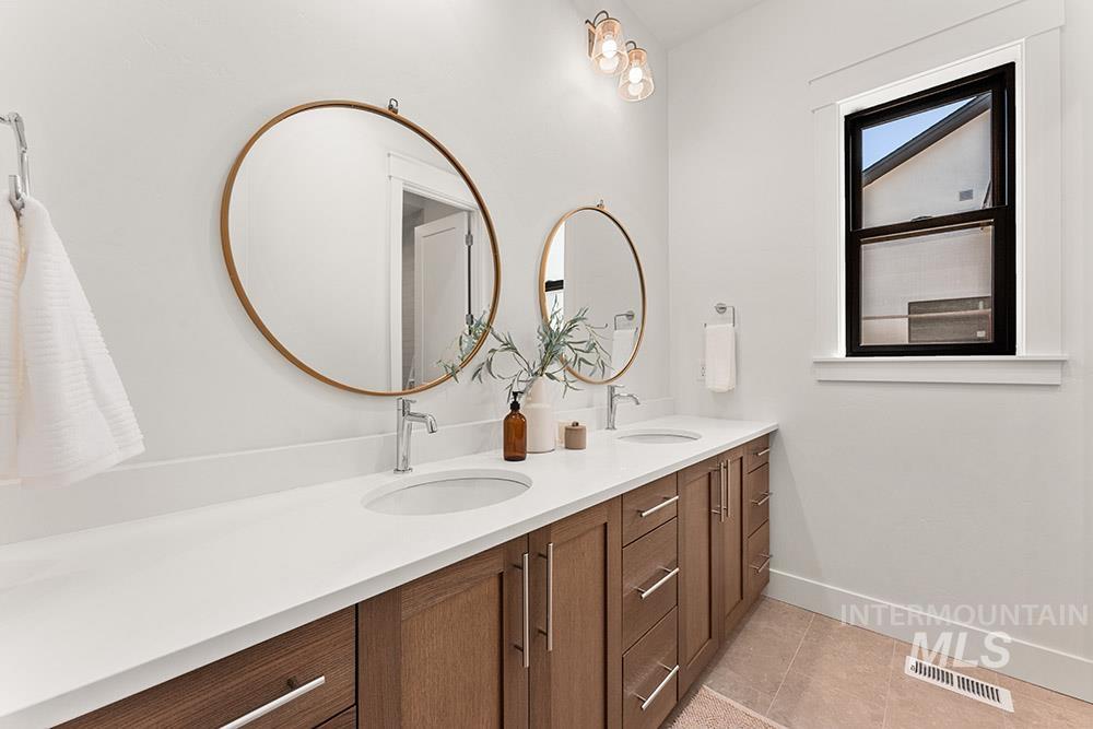 Bathroom featuring double vanity and light tile patterned floors