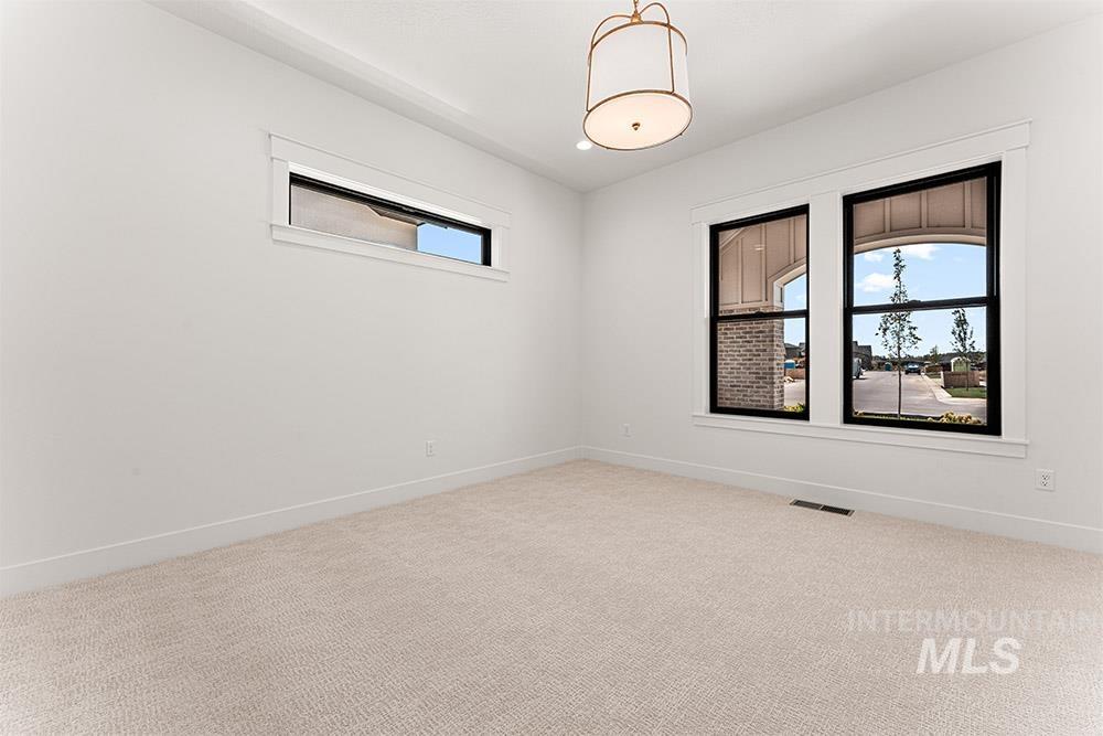 Spare room featuring light carpet and baseboards