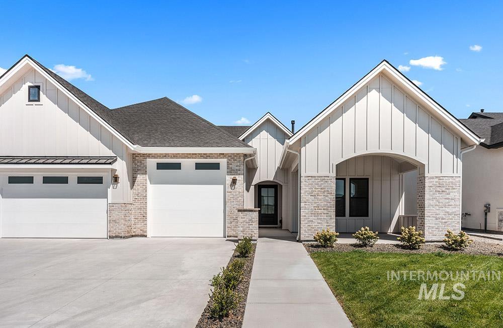 Modern farmhouse with board and batten siding, concrete driveway, a garage, a front lawn, and a shingled roof