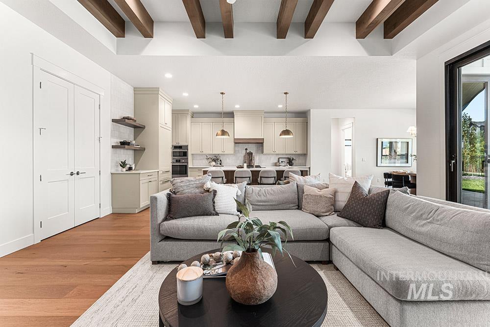 Living area featuring light wood-style floors, beamed ceiling, and recessed lighting
