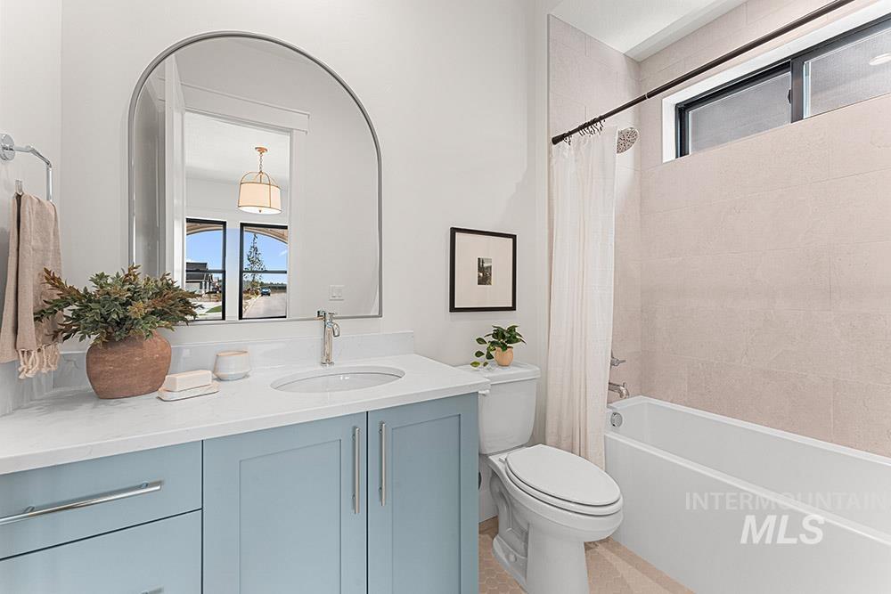 Full bathroom featuring plenty of natural light, shower / bathtub combination with curtain, vanity, and light tile patterned floors