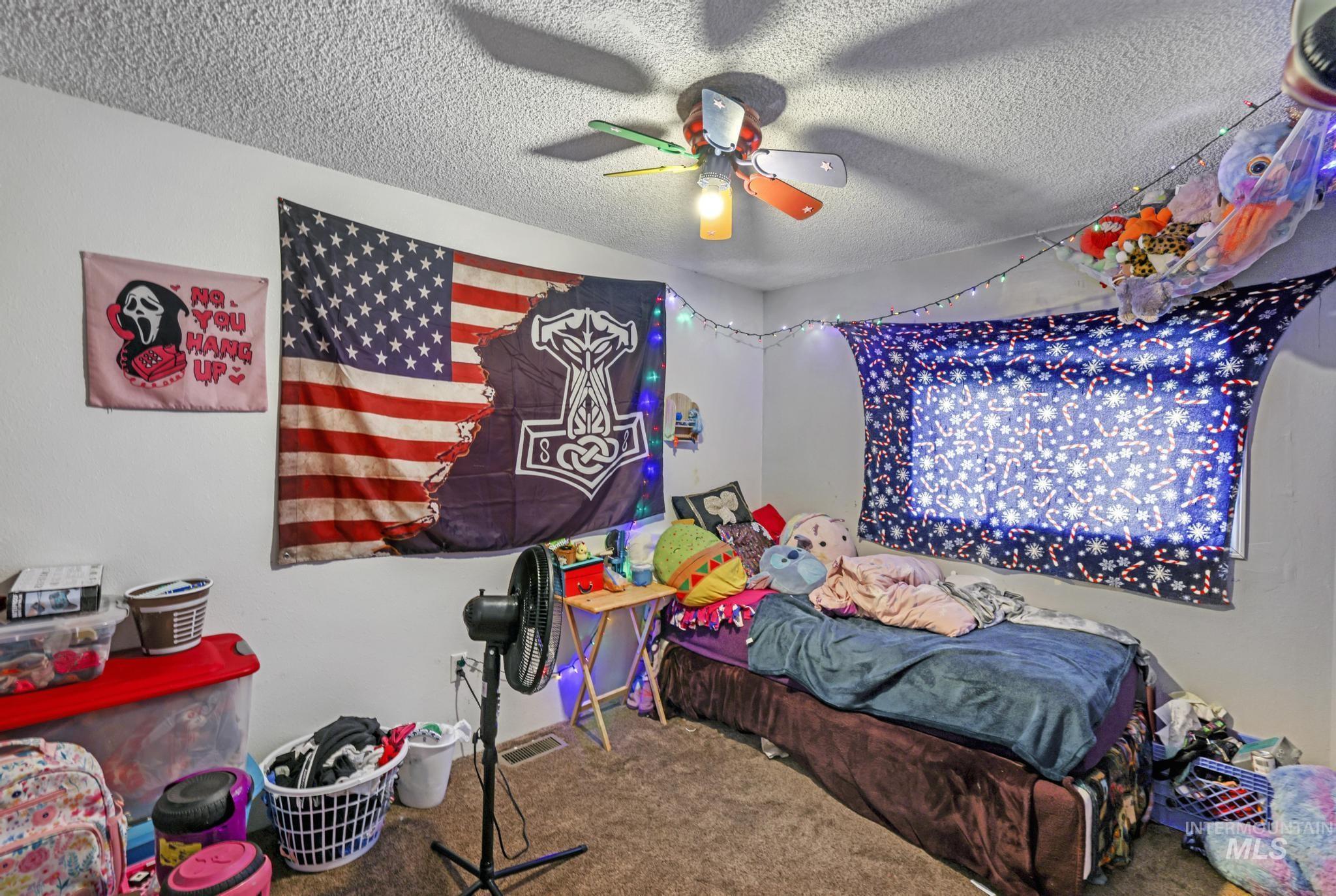 Bedroom featuring carpet floors and a textured ceiling