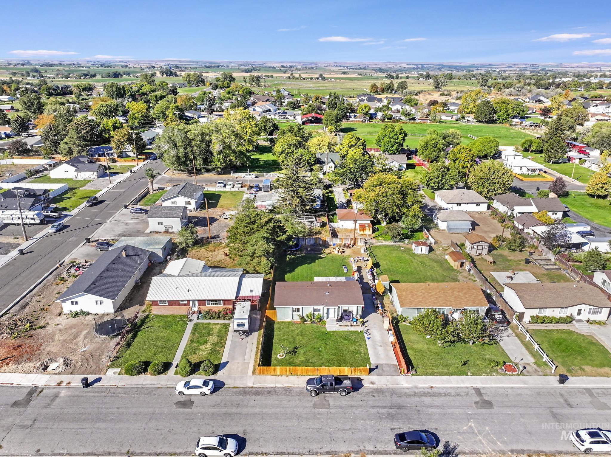 Aerial view of property and surrounding area with nearby suburban area