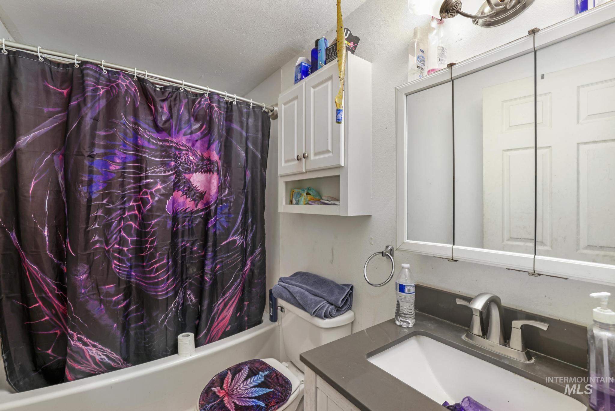 Bathroom featuring shower / bath combination with curtain and vanity