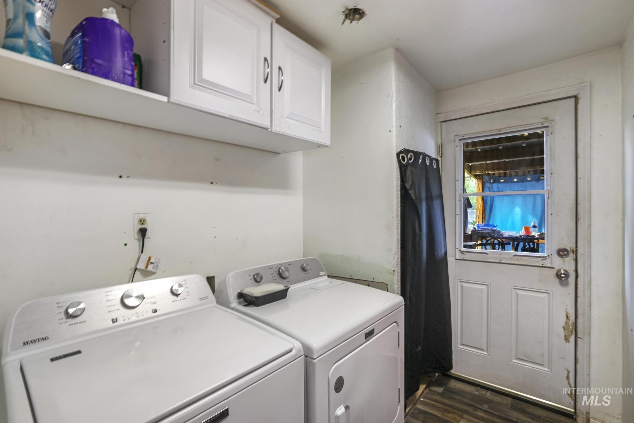Laundry room featuring cabinet space, dark wood-style flooring, and washing machine and dryer