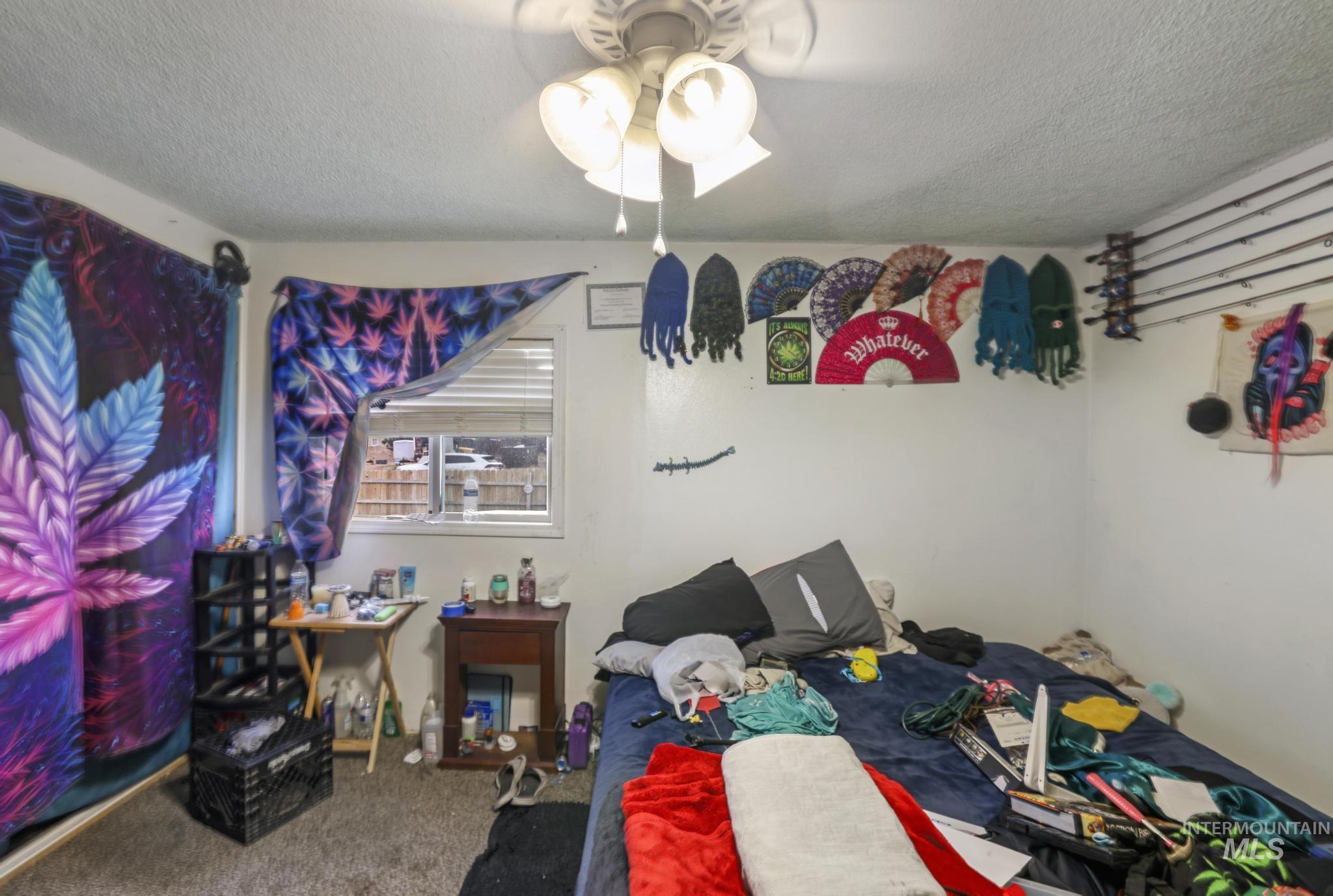 Bedroom featuring a textured ceiling, carpet, and ceiling fan