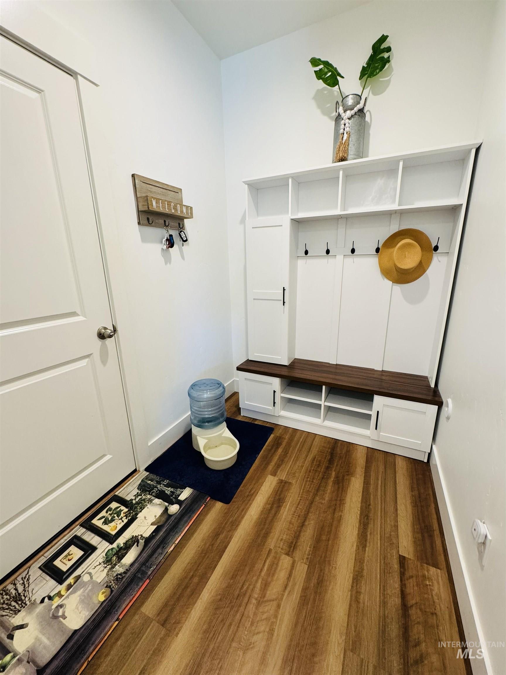Mudroom with dark wood-type flooring and baseboards