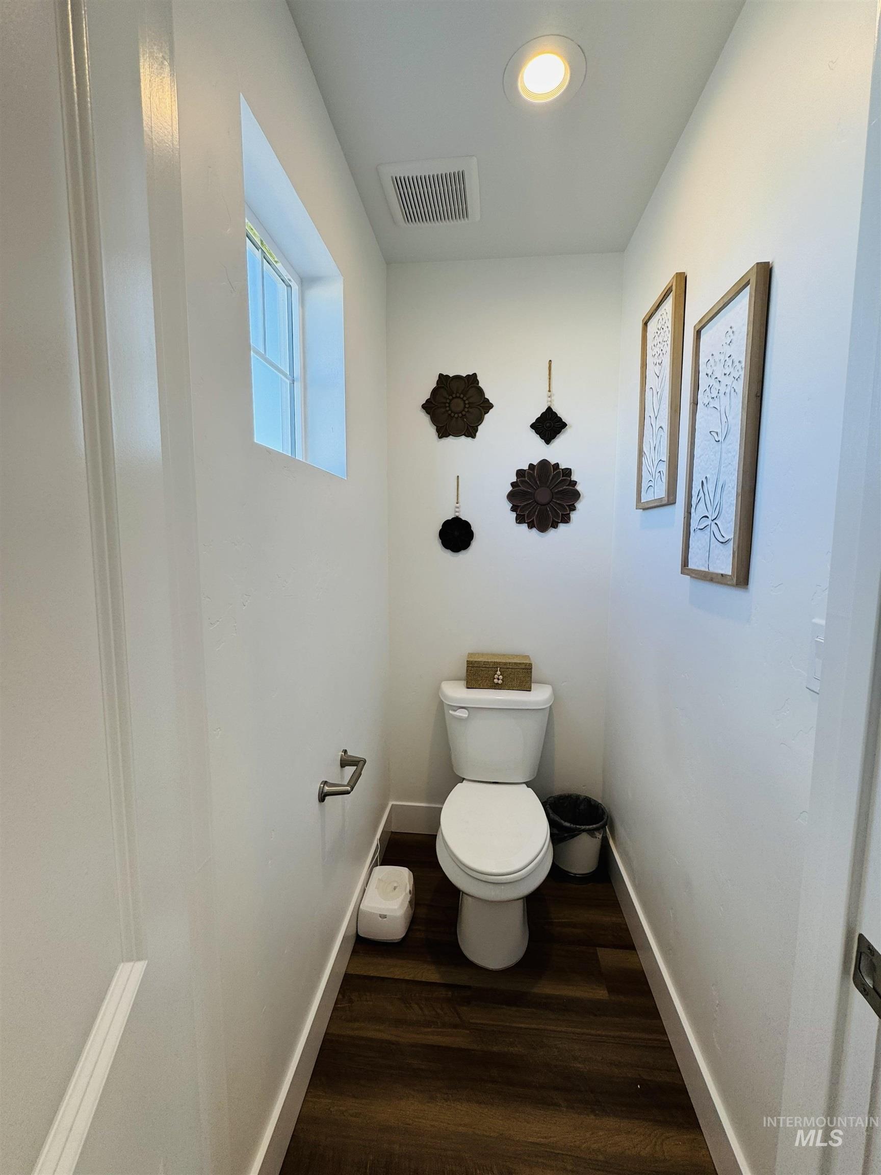 Bathroom featuring toilet and dark wood-type flooring