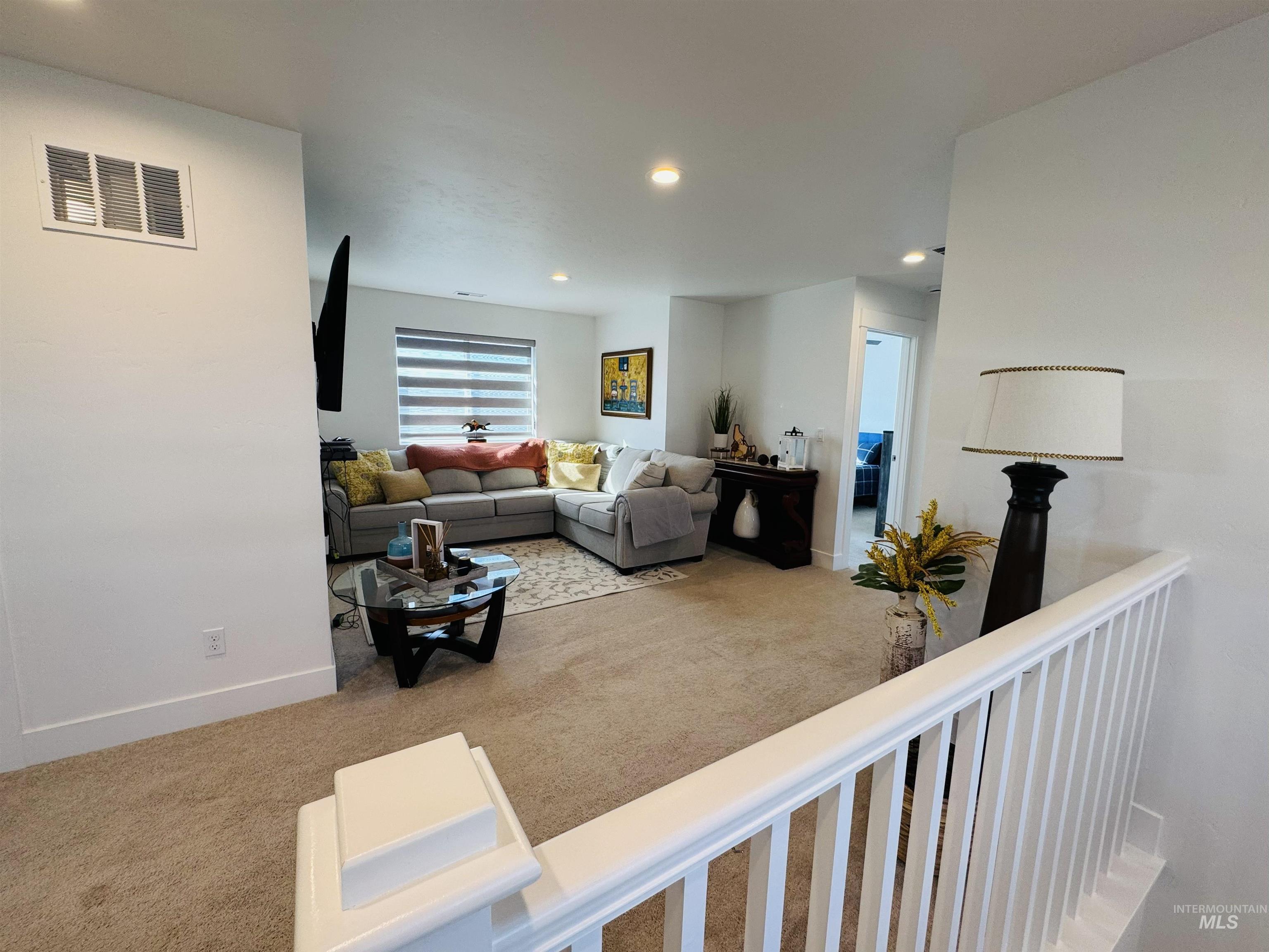Living area featuring light colored carpet and recessed lighting