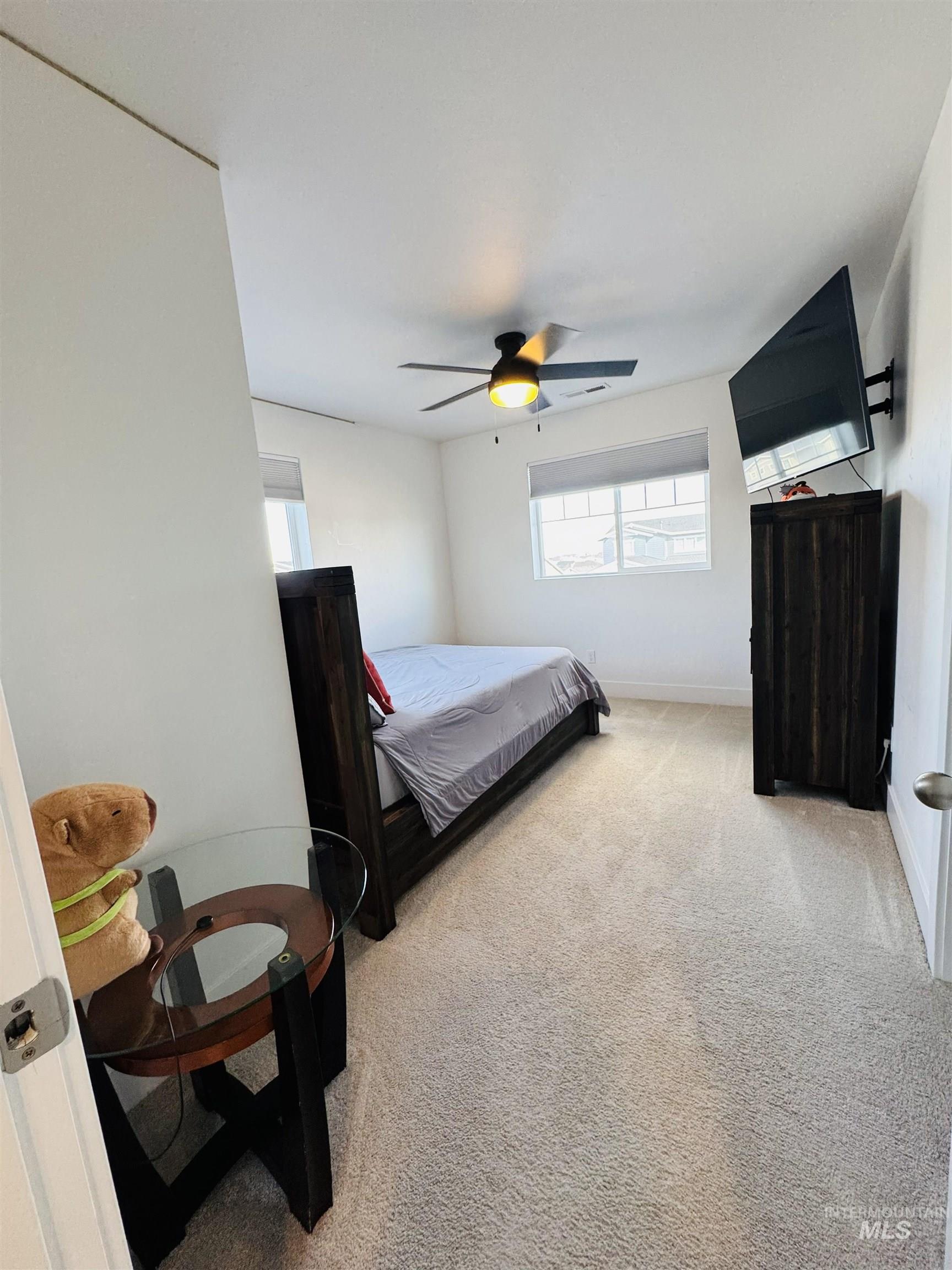 Bedroom featuring light carpet and a ceiling fan