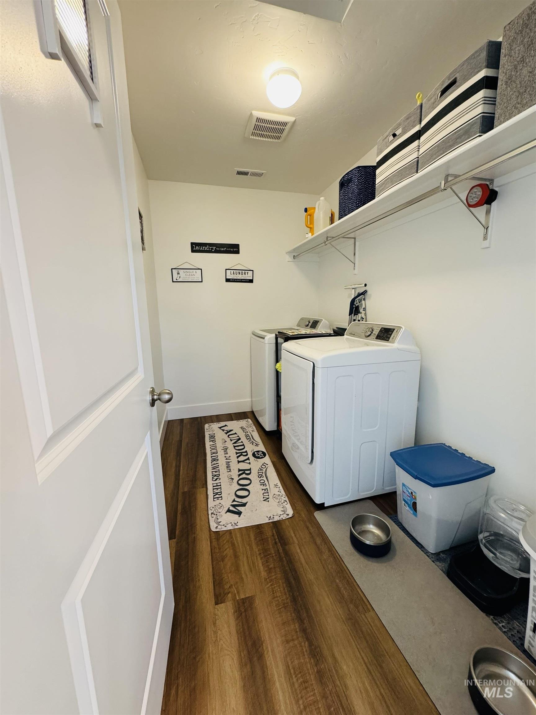 Laundry area with dark wood-style flooring and washer and dryer