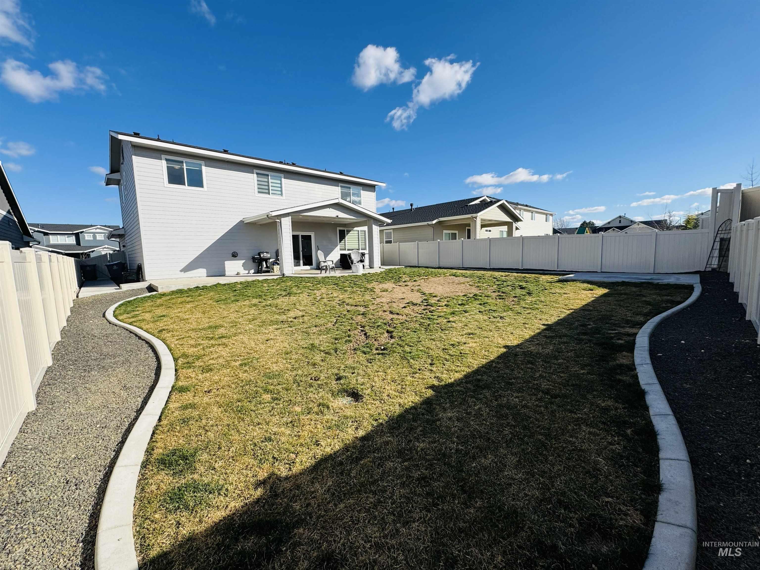 Rear view of house with a patio and a fenced backyard