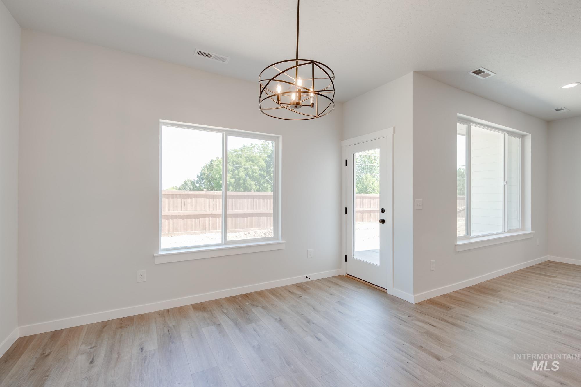 Unfurnished dining area with light wood-style flooring and a chandelier