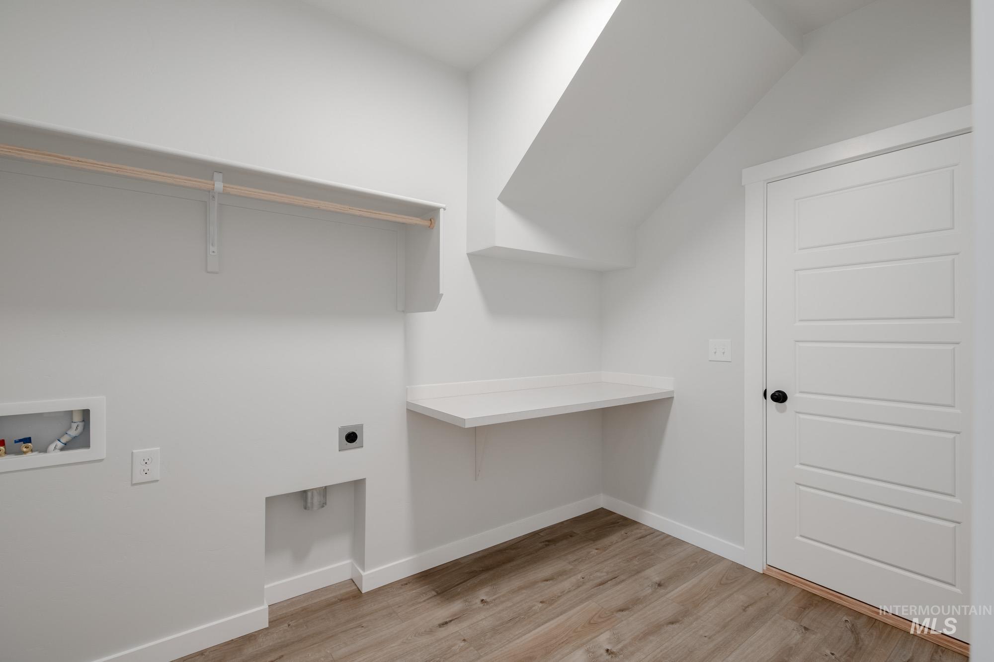 Laundry area with light wood-style flooring, electric dryer hookup, and washer hookup