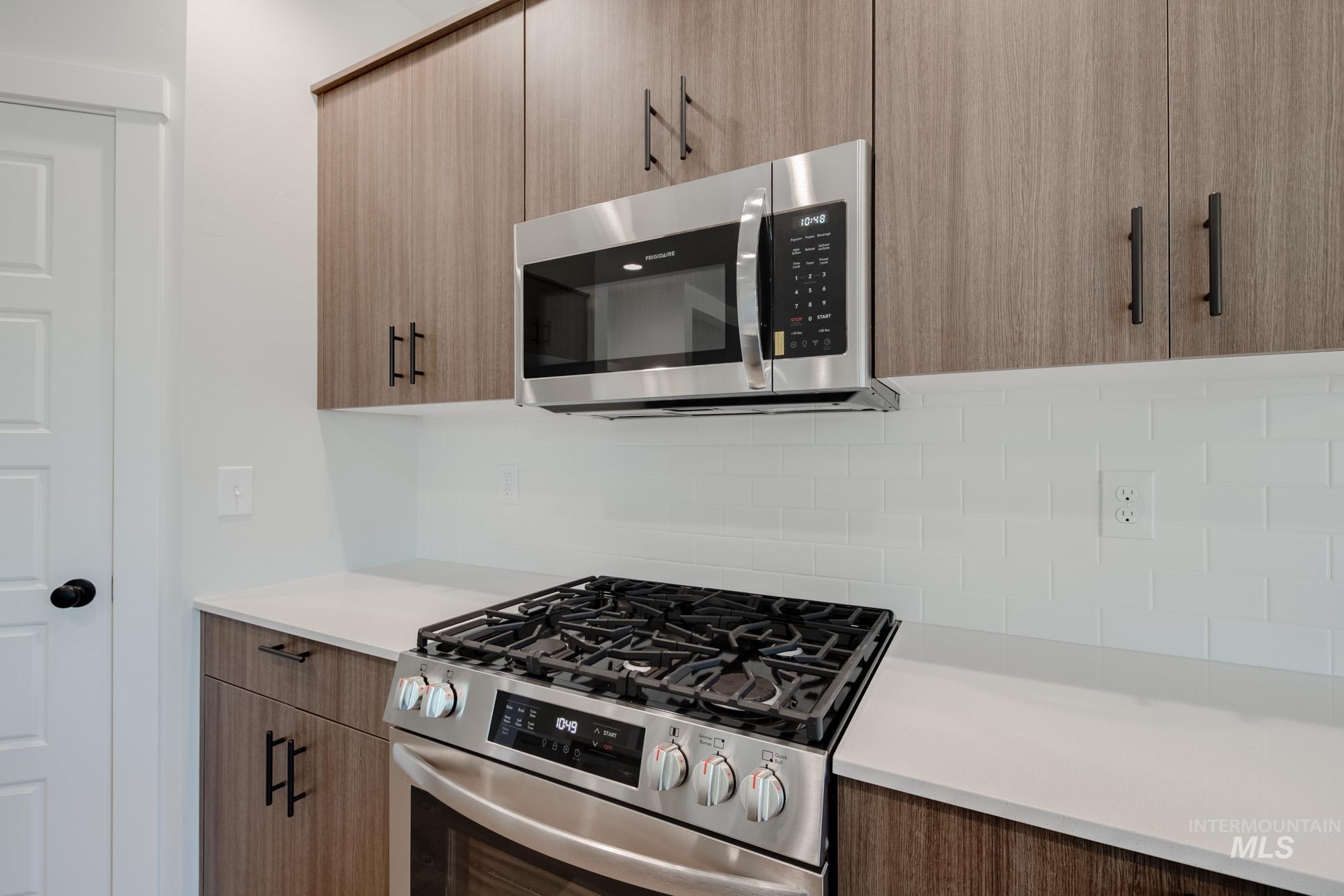 Kitchen featuring stainless steel appliances, modern cabinets, and decorative backsplash