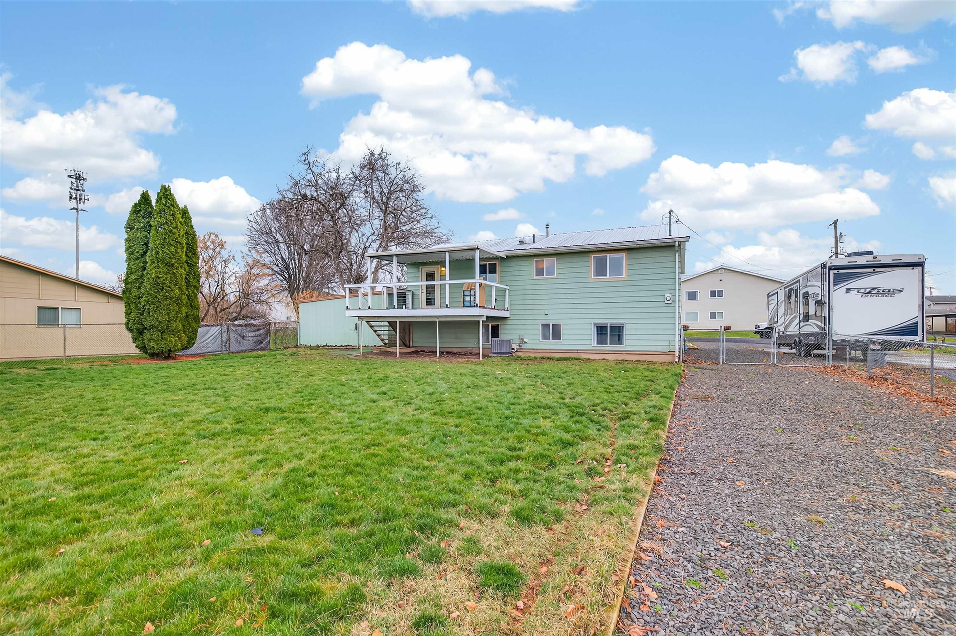Rear view of property with a fenced backyard, a gate, and a wooden deck