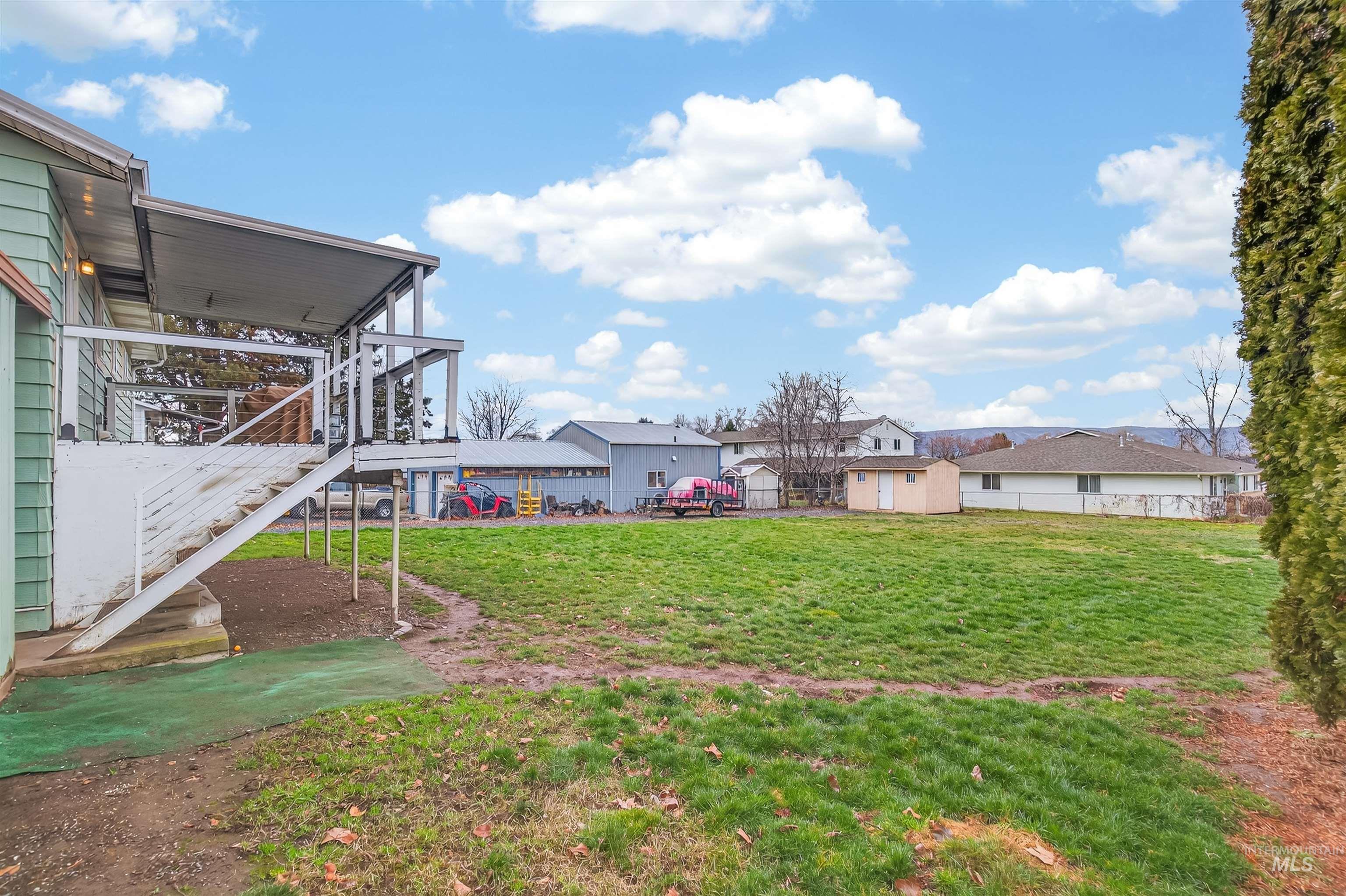 Fenced backyard with a patio, a storage shed, and a deck
