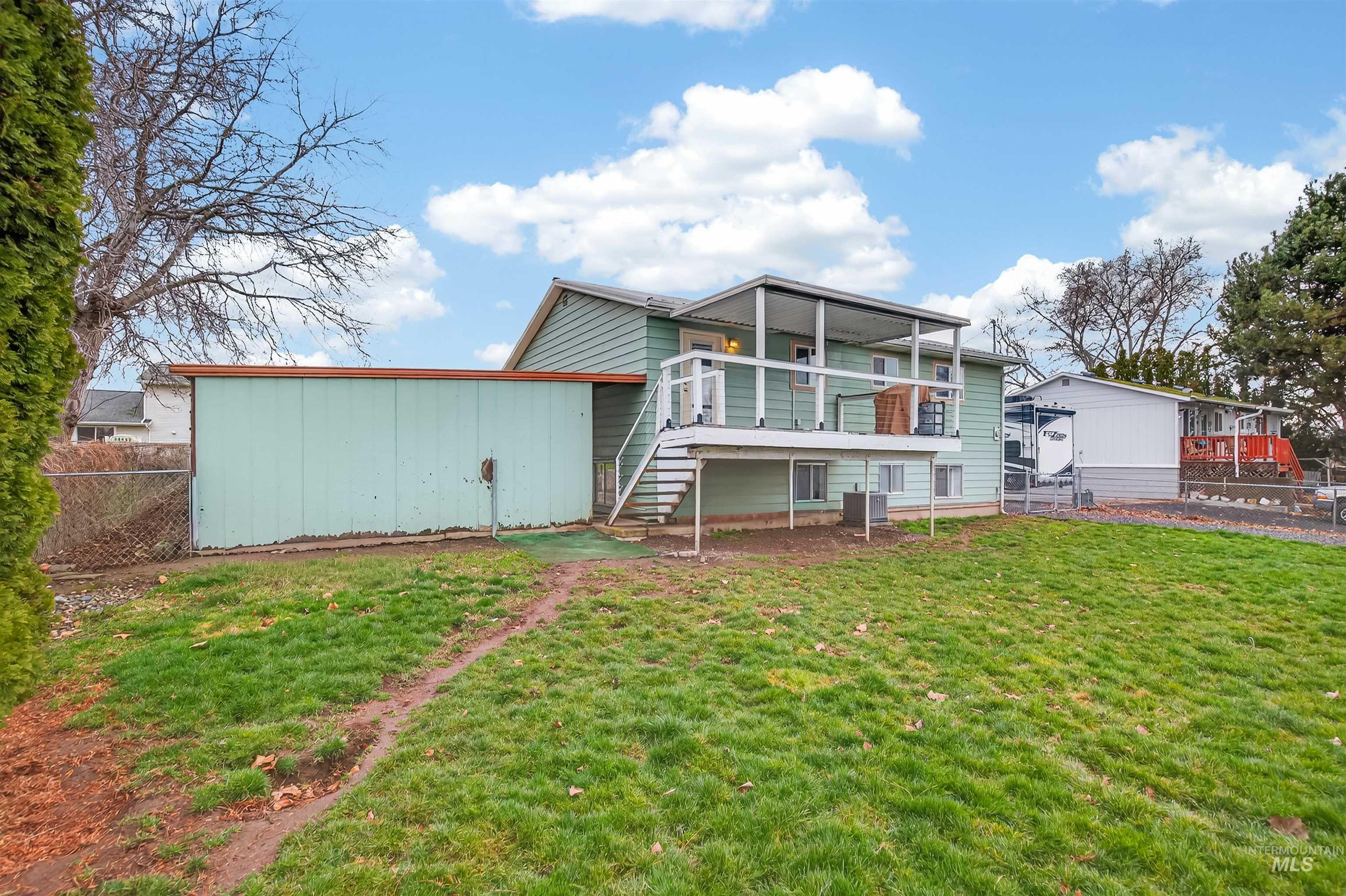 Rear view of house featuring stairs and a wooden deck