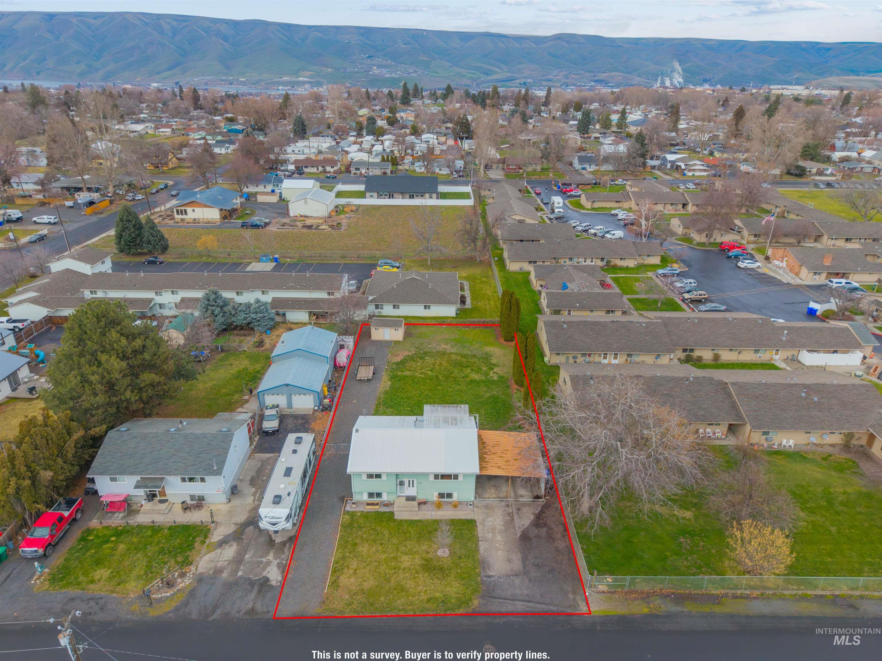 Aerial overview of property's location with property boundaries highlighted and a mountain backdrop