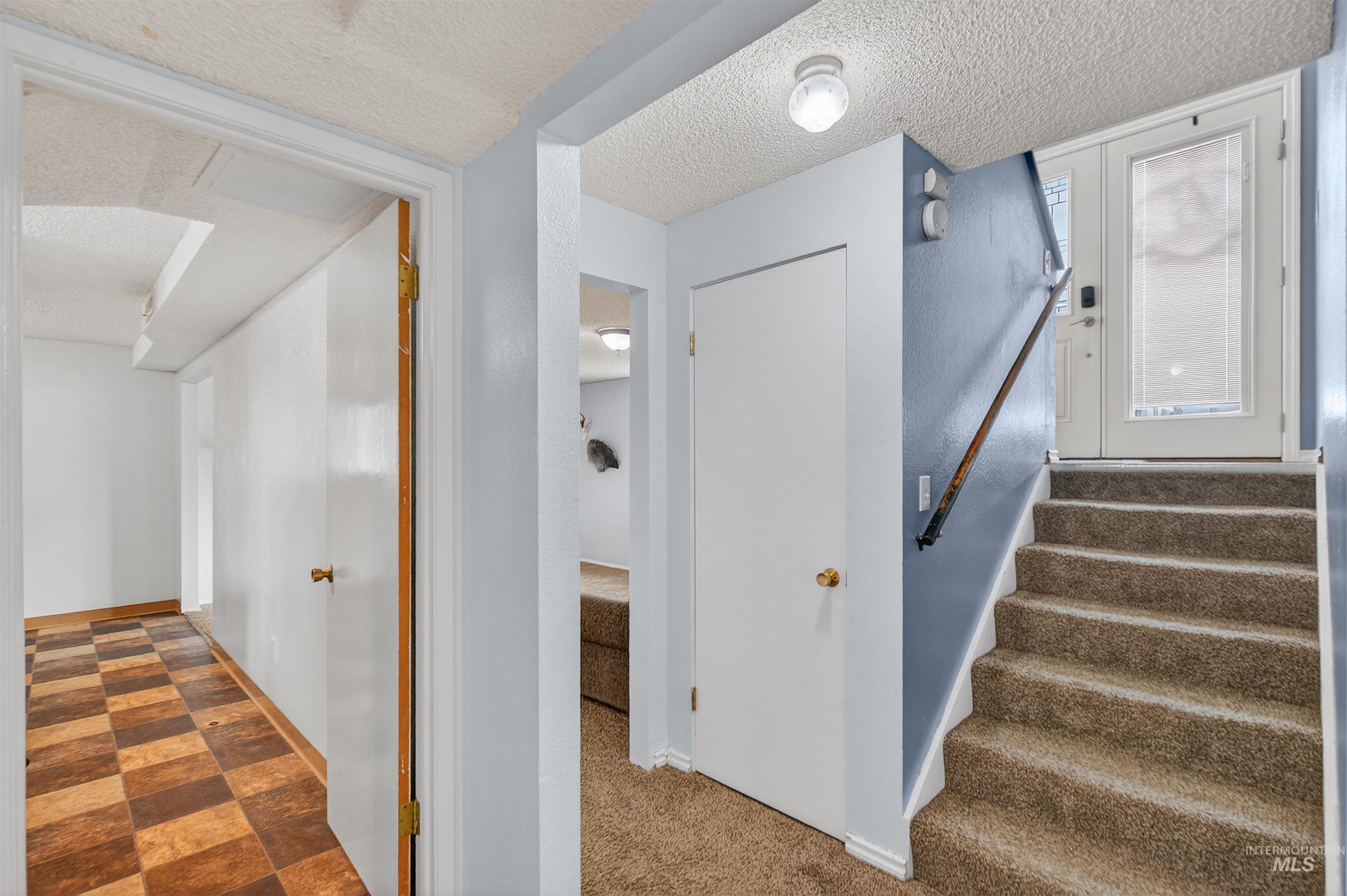 Staircase with a textured ceiling and tile patterned floors