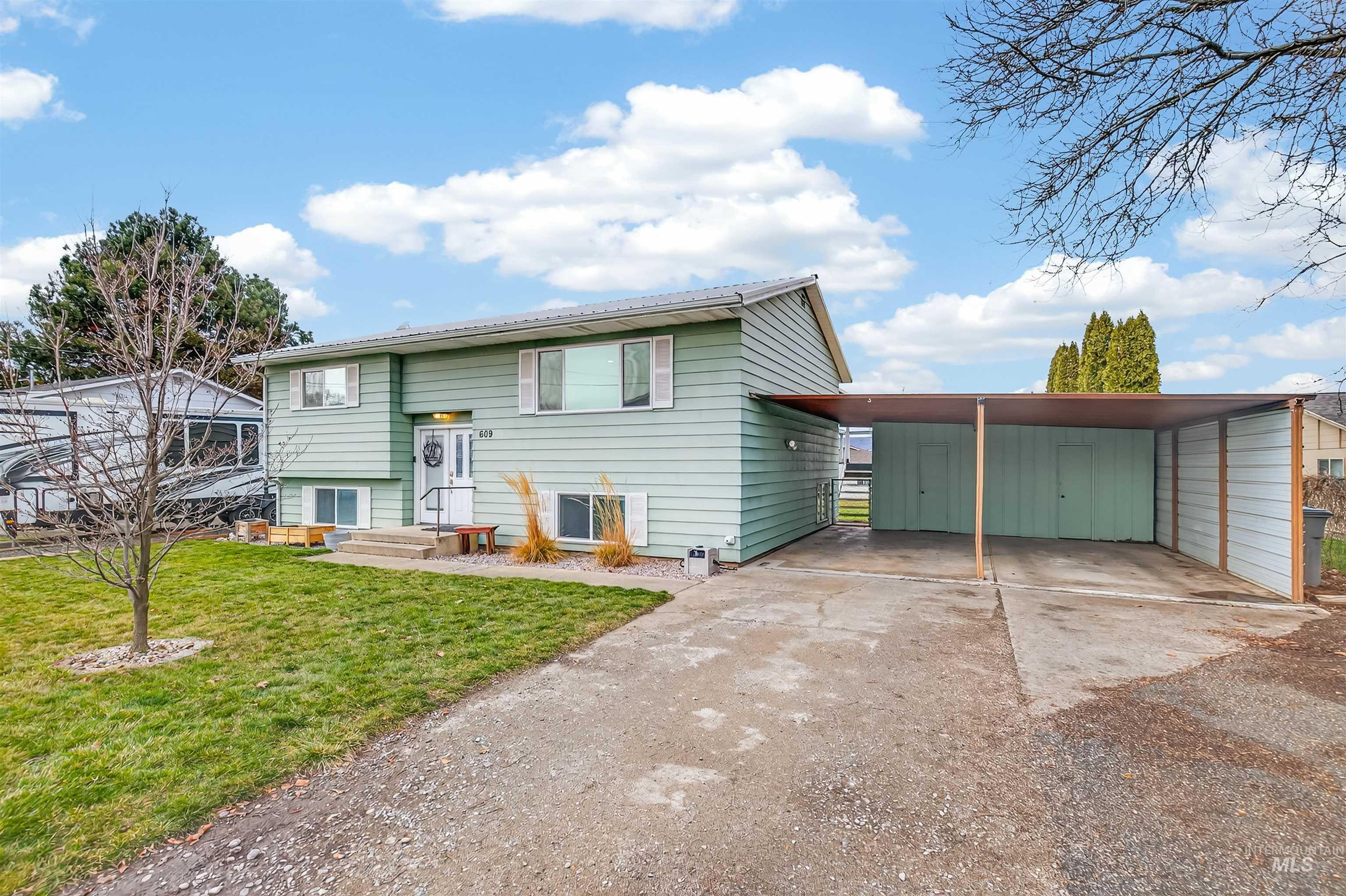 Bi-level home with concrete driveway and a front lawn