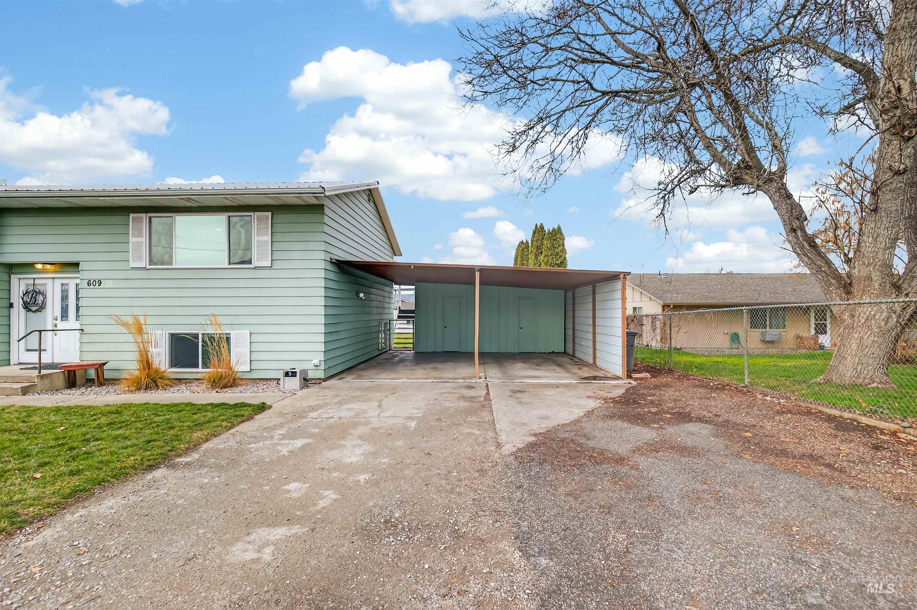 View of front of house featuring driveway, a front lawn, and an attached carport