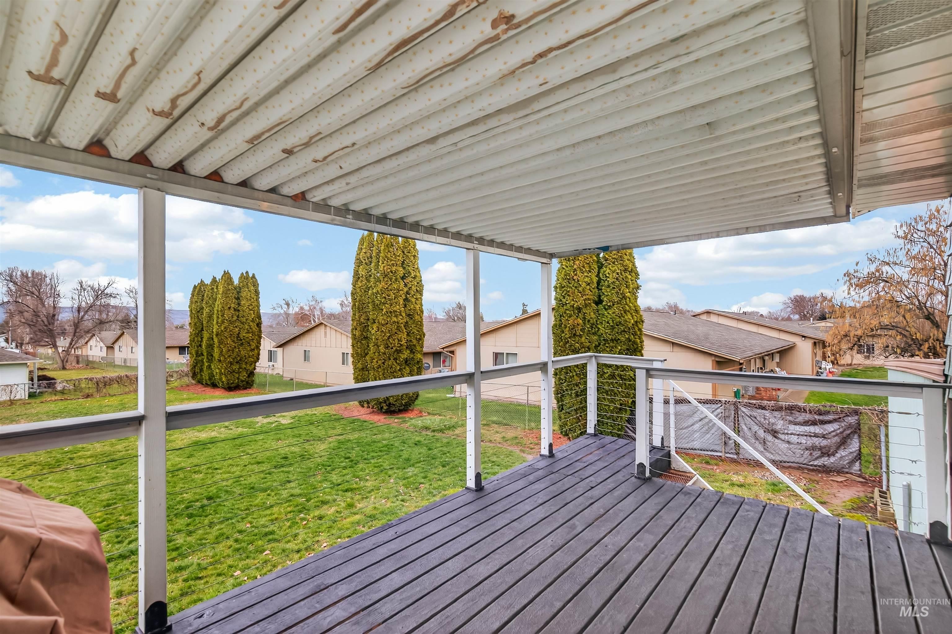 Wooden terrace with a lawn and a residential view