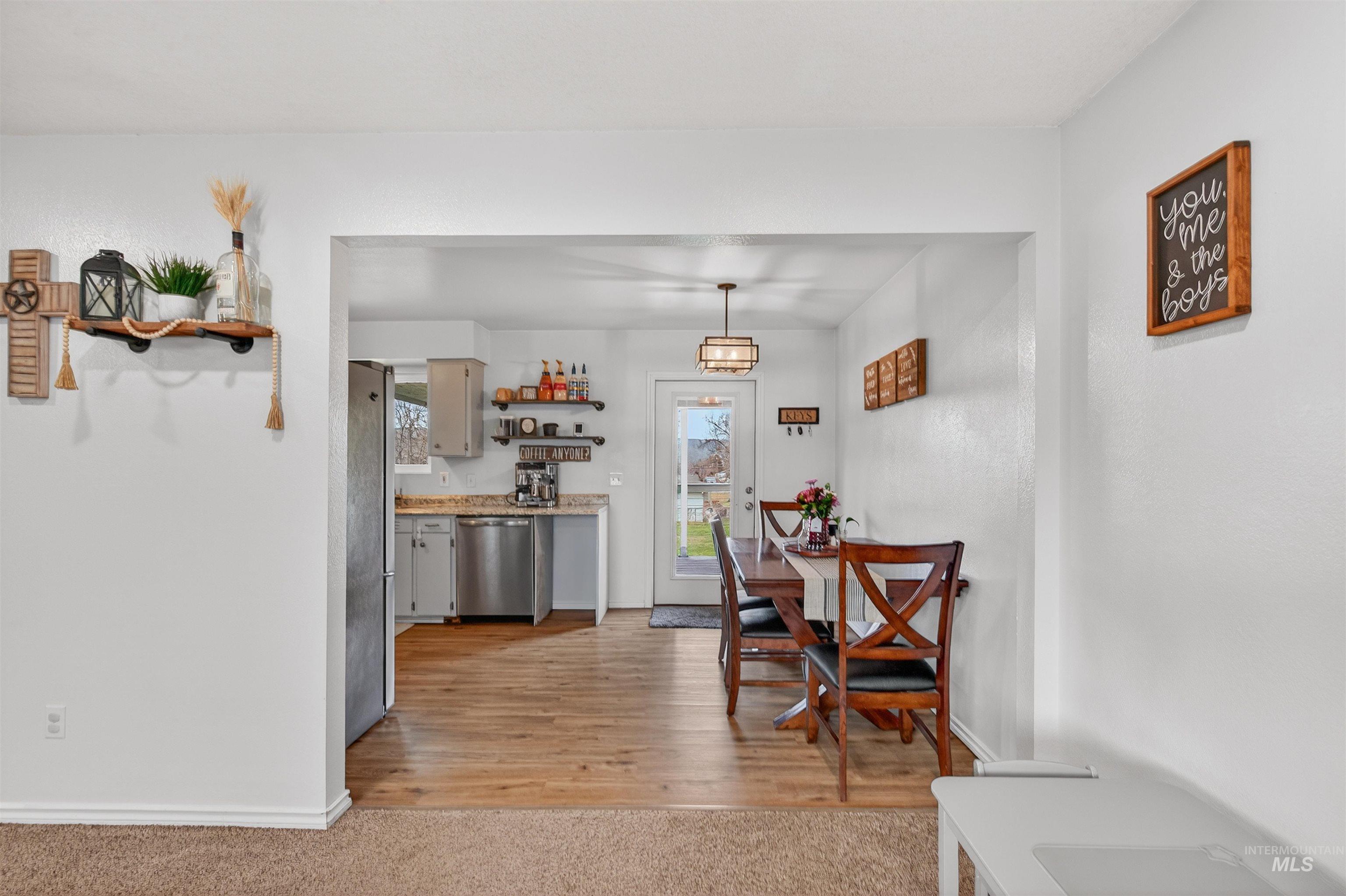 Dining space with light wood-type flooring and light colored carpet