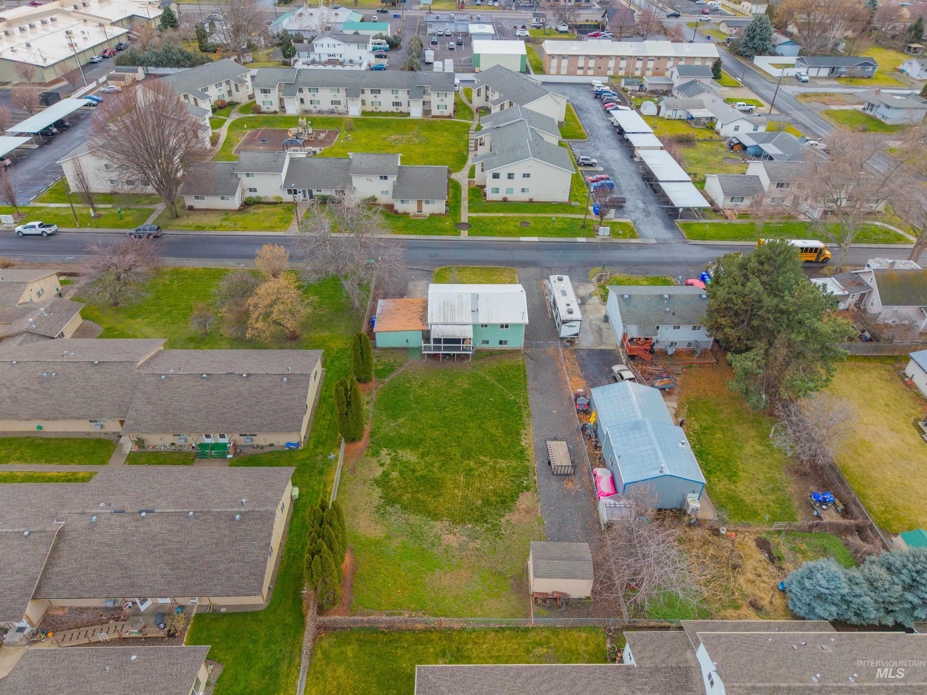 Aerial view of property and surrounding area featuring nearby suburban area