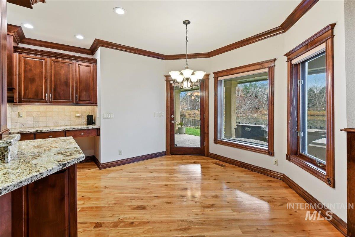 Unfurnished dining area featuring a chandelier, light wood-style floors, ornamental molding, and recessed lighting