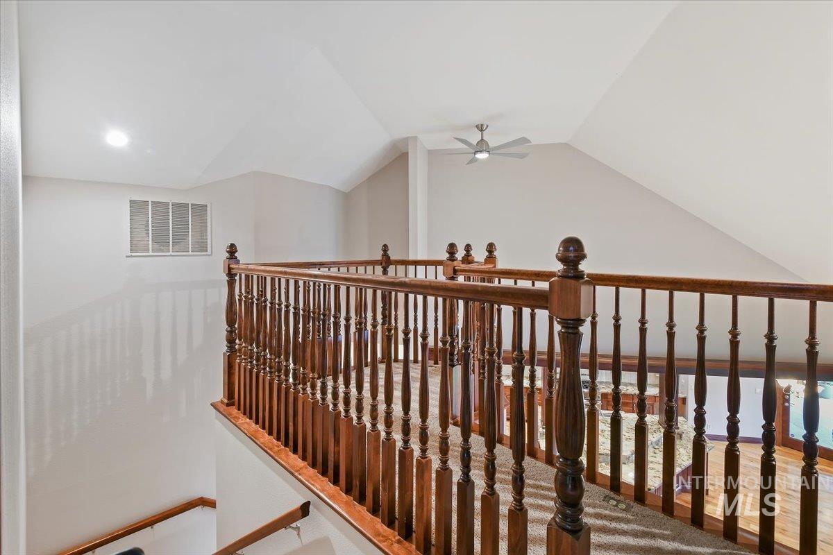 Hallway with an upstairs landing and lofted ceiling