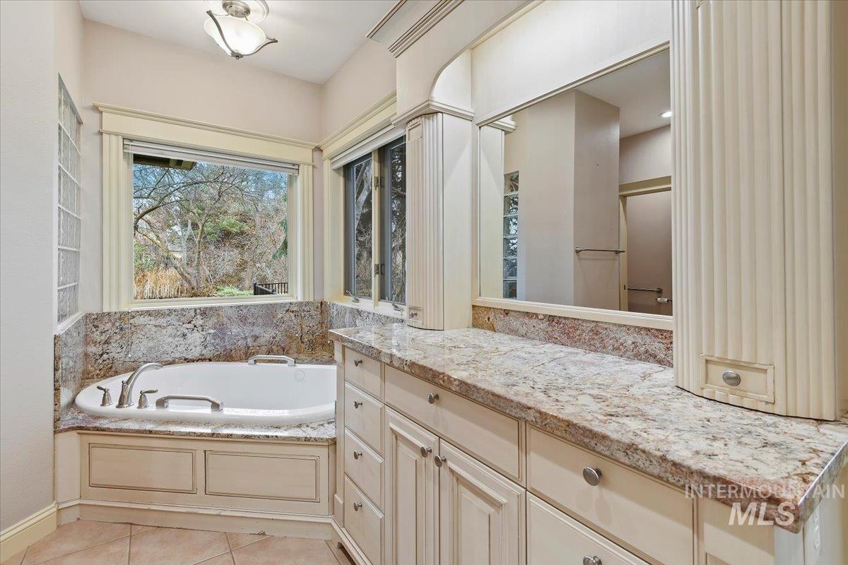 Full bathroom featuring a garden tub, light tile patterned floors, a shower, and vanity